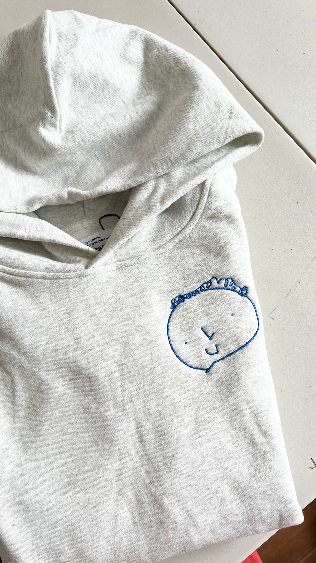 A drawing of a gift embroidered on a premium hoodie with royal blue, the perfect father’s day gift Australia